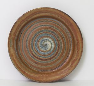 Large platter in rustic brown with a spiral decoration in rutile.